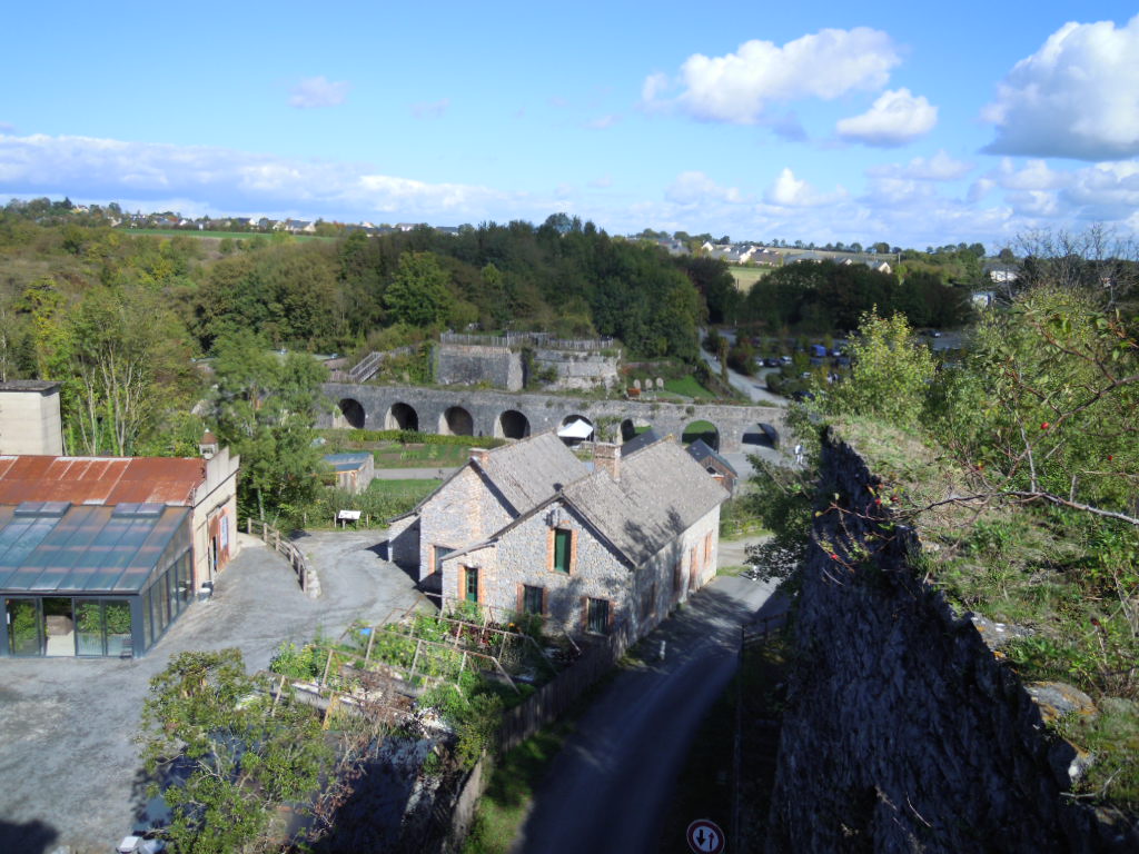 Une petite  partie du site Echlogia, vue du sommet d'un des fours à chaux. A gauche la serre aquaponique et la zone de reproduction des saumons de fontaine.