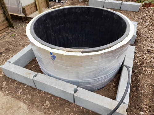 La cuve de 750 litres, isolée, enterrée de 20 cm, avec l'amorce du muret de coffrage.